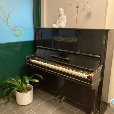 Ein Klavier steht im Gang zu den Coaching-Räumlichkeiten
