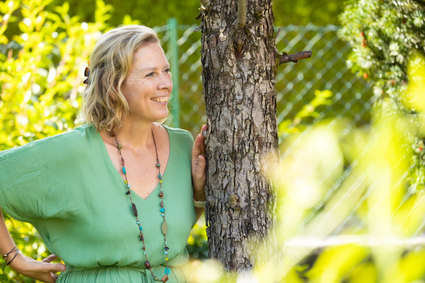 Martina Klein (4) Martina Klein - angelehnt an einen Baum - lächelnd in die Ferne blickend